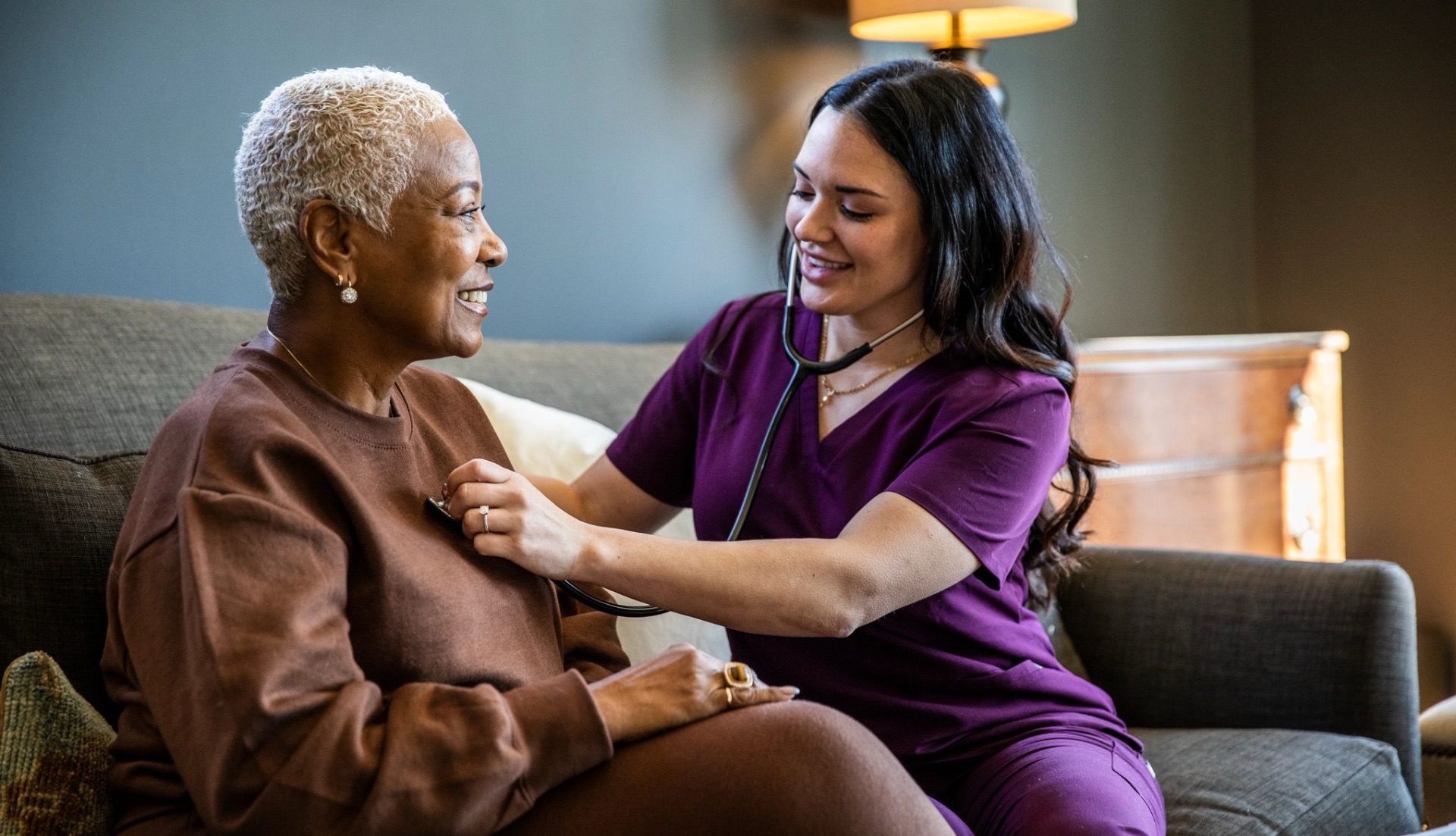 Compassionate caregiver sharing a warm moment with a smiling senior at home