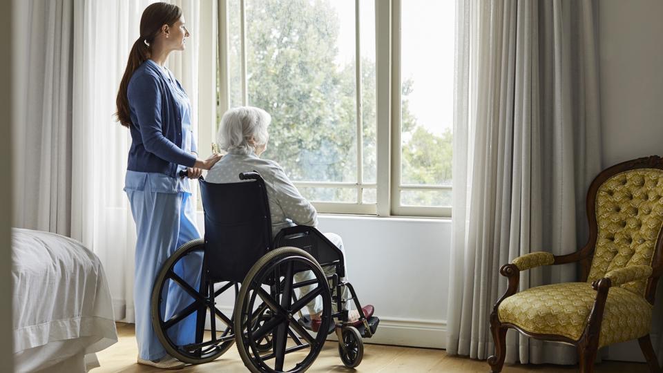 Caregiver and senior enjoying a calm, dignified moment by the window
